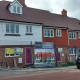 Row of new terraced houses under construction, scaffolding on one side, sign about development in front.