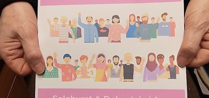 Person holding a leaflet for community councillor recruitment in Salehurst & Robertsbridge, calling for "community heroes.