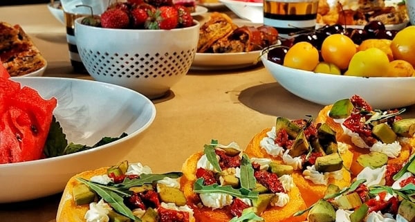 a table topped with plates of food and bowls of fruit
