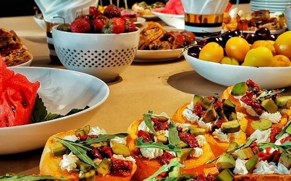 a table topped with plates of food and bowls of fruit
