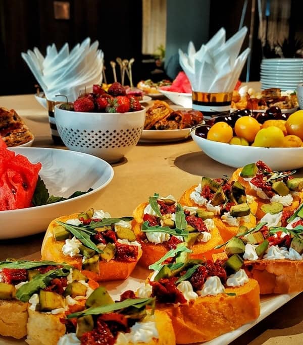 a table topped with plates of food and bowls of fruit